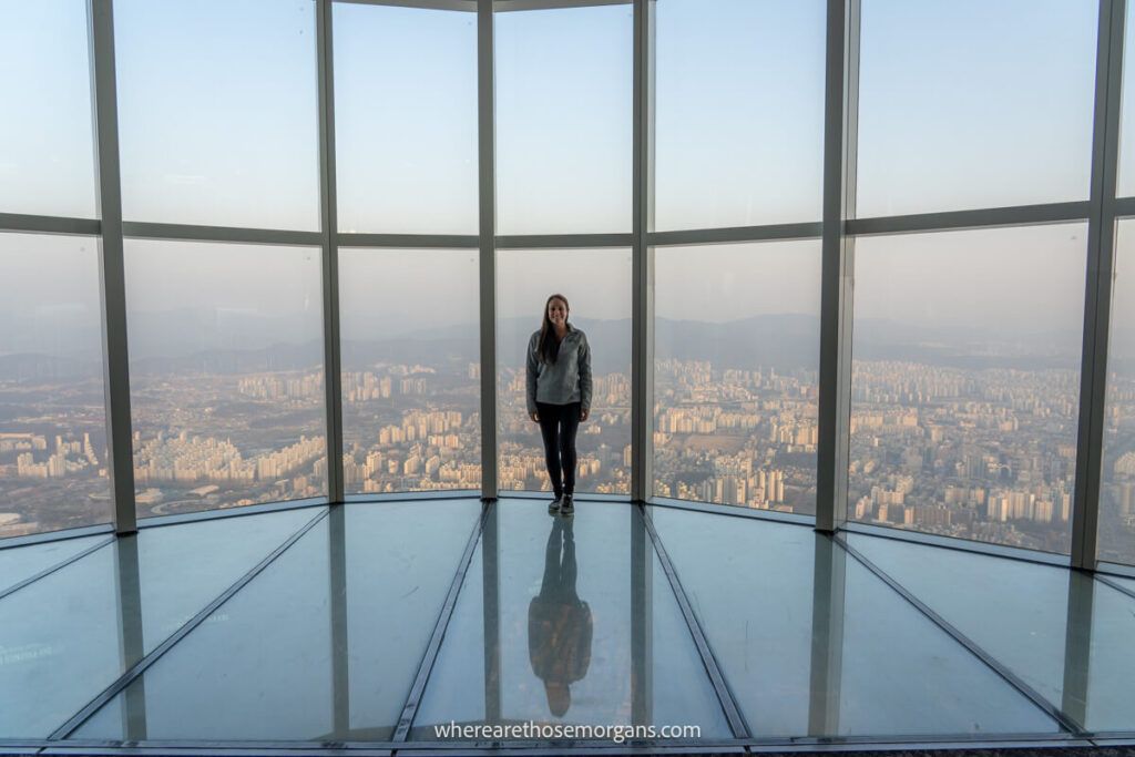 Tourist standing on a large glass window at Seoul Sky one of the best things to do in Seoul