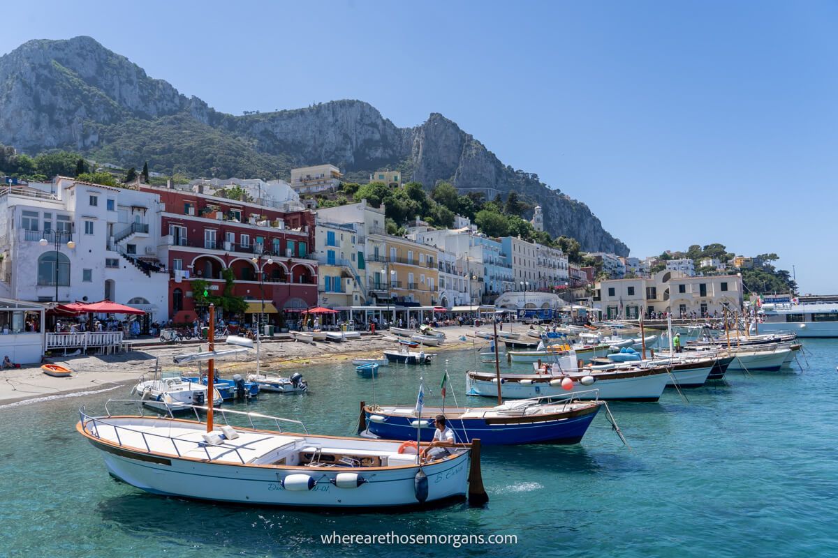 Capri coastline with  boats in the shallow water and buildings lining the shore