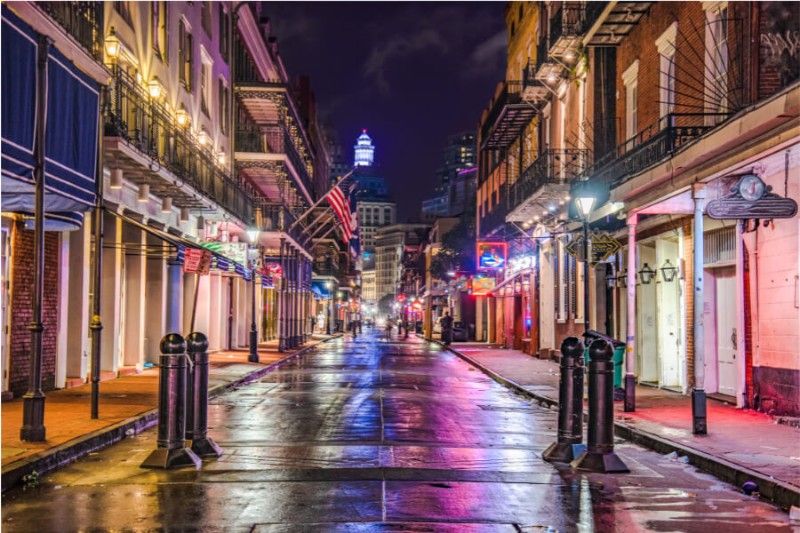 New Orleans Bourbon Street at the heart of the French Quarter lights glowing at night and reflecting in rainwater