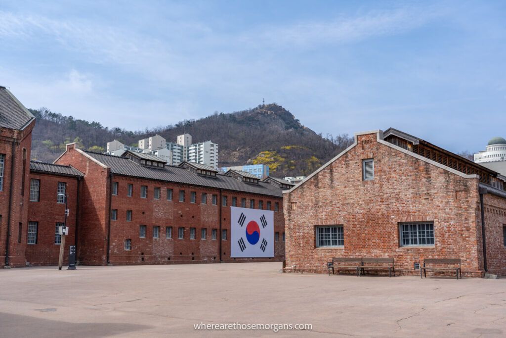 Brick buildings inside Seodaemun Prison with Inwangsan Peak in the distance