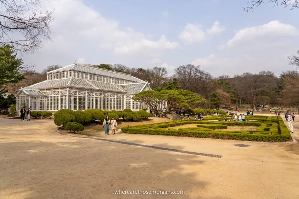 The white Grand Greenhouse inside Changgyeonggung Palace with maze out front of the building