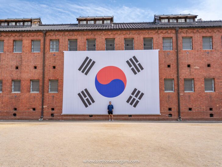 Visitors taking a picture in front of a very large Korean flag inside Seodaemun Prison