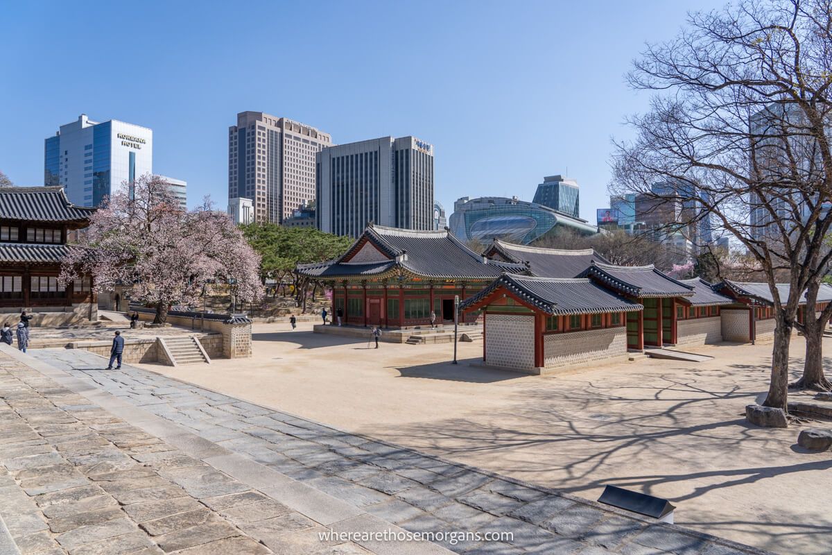 Numerous buildings at Deoksugung Palace with Seoul city skyline in the background