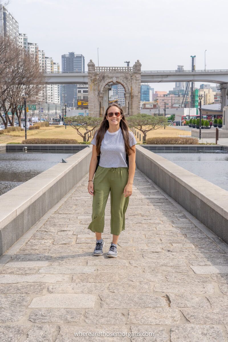 Visitor posing for a photograph near an old gate
