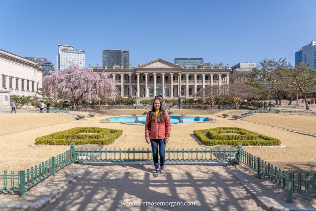 Woman posing for a photo in front of the fountain at Deoksugung