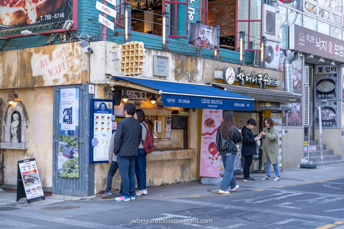 Visitors purchasing a waffle along Gojonguigil Pathway near Deoksugung Palace