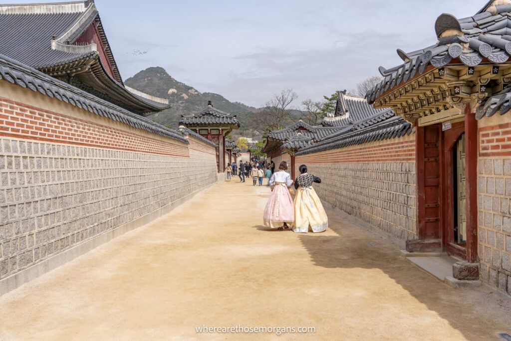 Two visitors walking around Seoul wearing hanboks