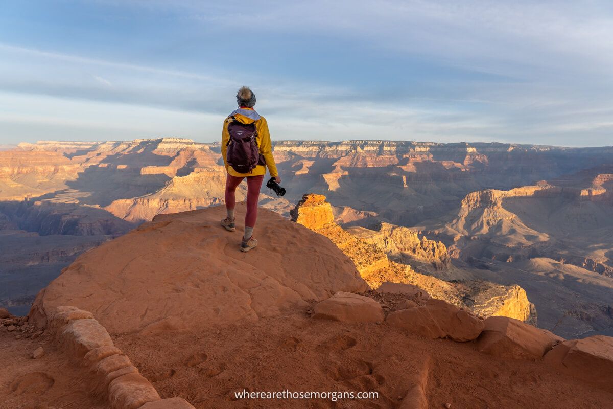 Photographer hiking down into the Grand Canyon during sunrise on a cold day in December