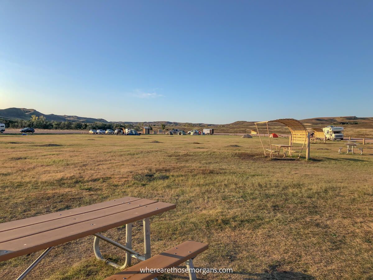 Open grassy field with benches for camping in Badlands National Park