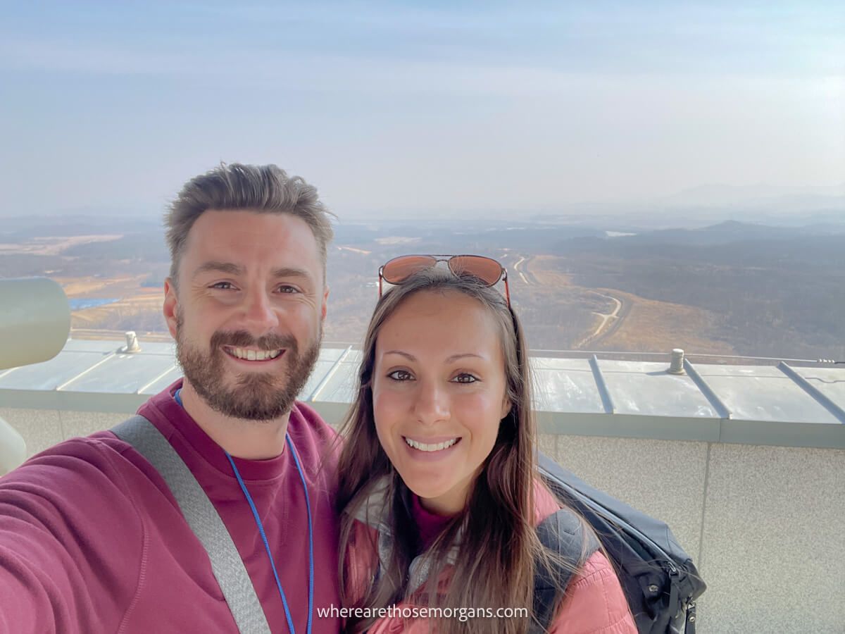 Man and woman taking a selfie with North Korea in the background