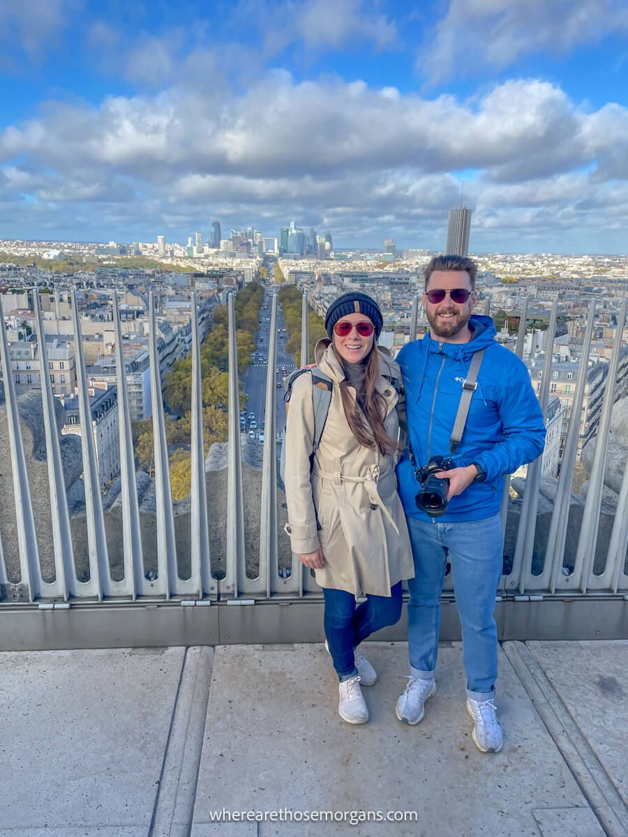 Two tourists posing for a photo on top of the Arc de Triomphe