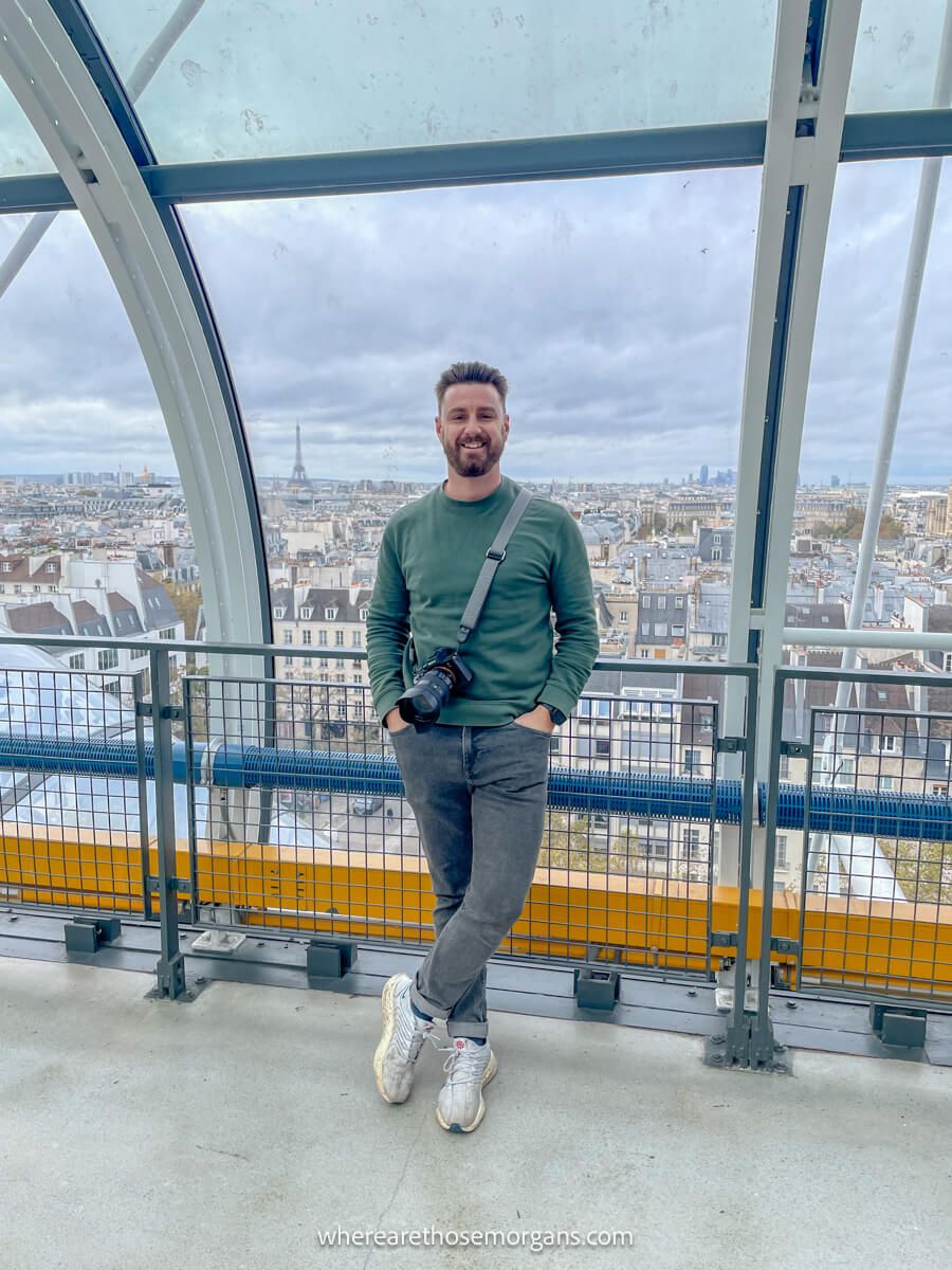 A visitor posing for a photo with the Eiffel Tower in the background