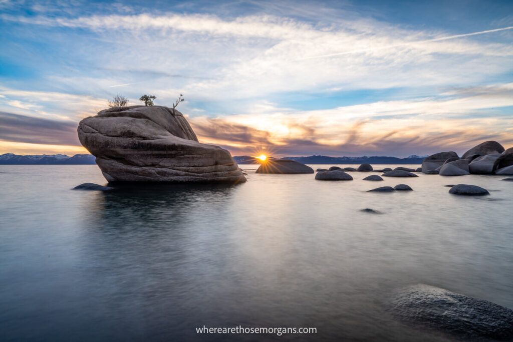 Sunset photography at Bonsai Rock in Lake Tahoe with water foreground rocky middle ground and cloudy sky background