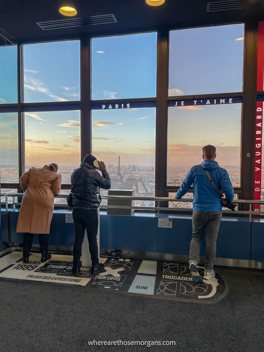 Man looking out through the windows at the Montparnasse Tower to the Eiffel Tower