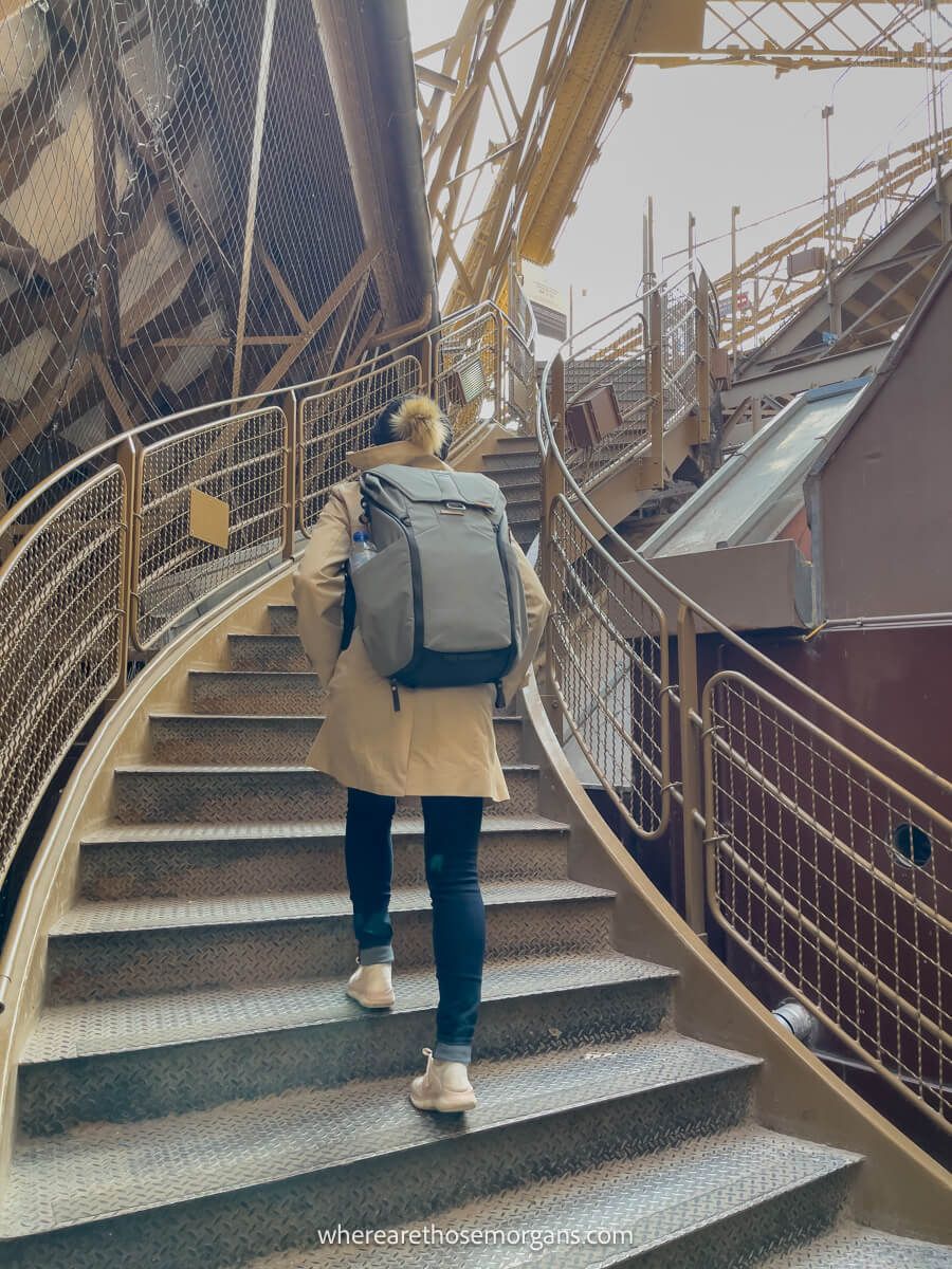Woman walking up the stairs to the Eiffel Tower in November