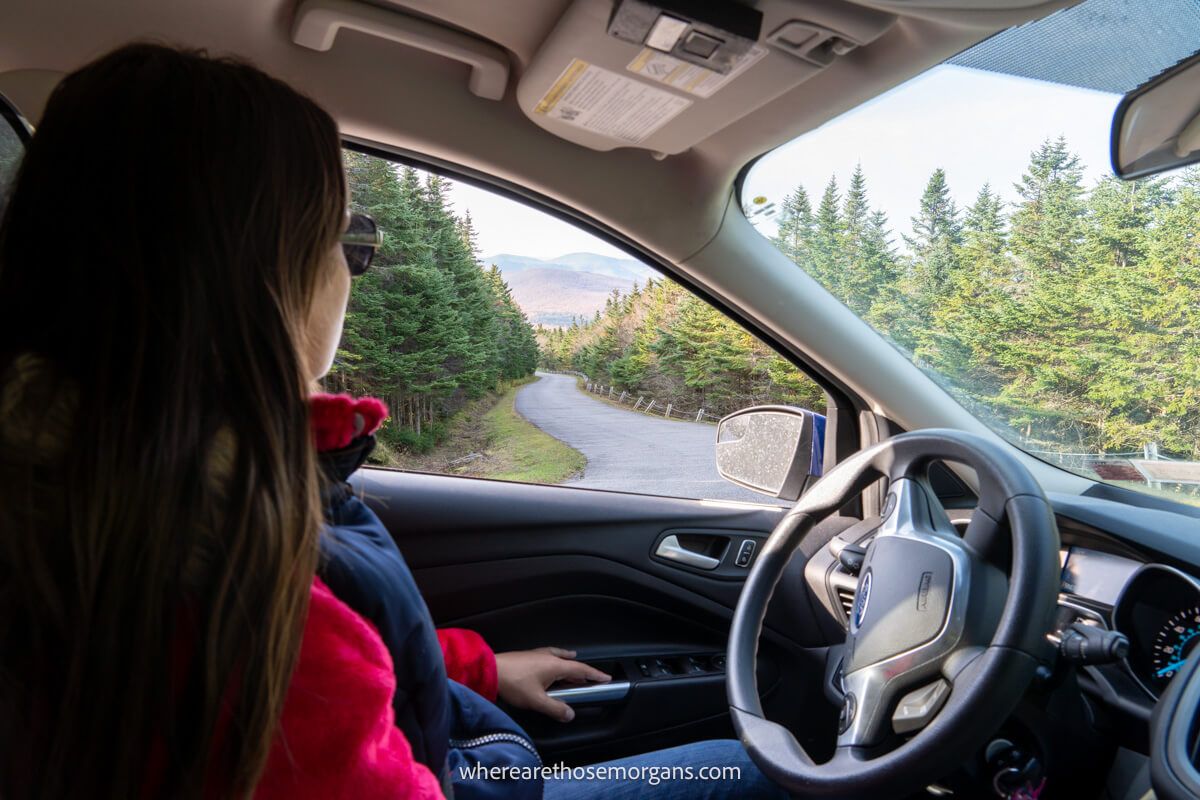 Woman looking out the window of a Ford SUV during a road trip