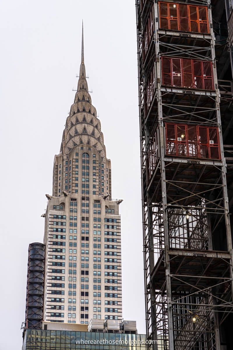 Art deco Chrysler Building against a cloudy sky with an elevator shaft on another building