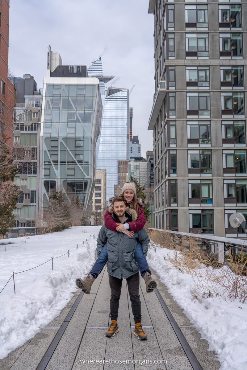 Elevated pedestrian walkway covered in snow with a person on another persons back