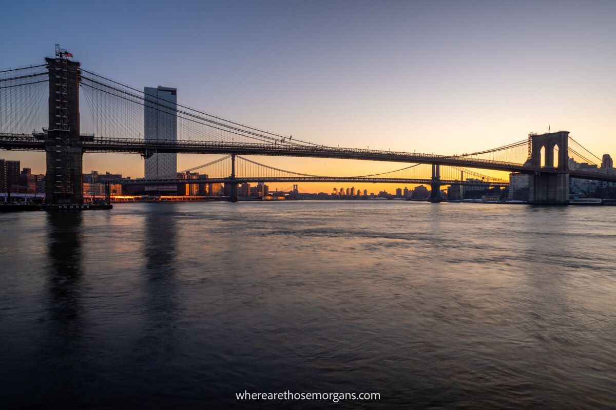 River and bridge silhouetted at sunrise with yellow and orange colors