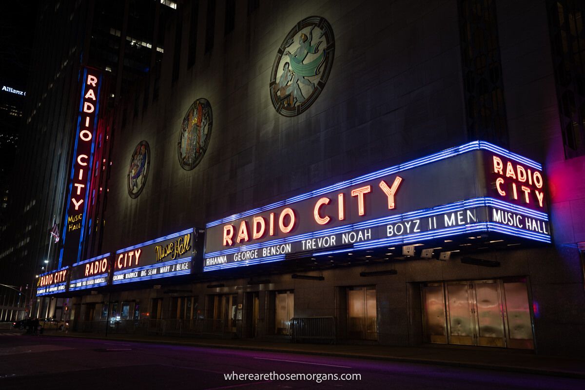 Radio City Music Hall in New York lit up with purples and reds at night
