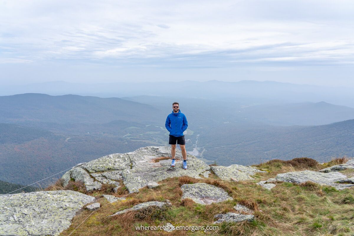 Hiker standing at the top of Mount Mansfield on a warm autumn day