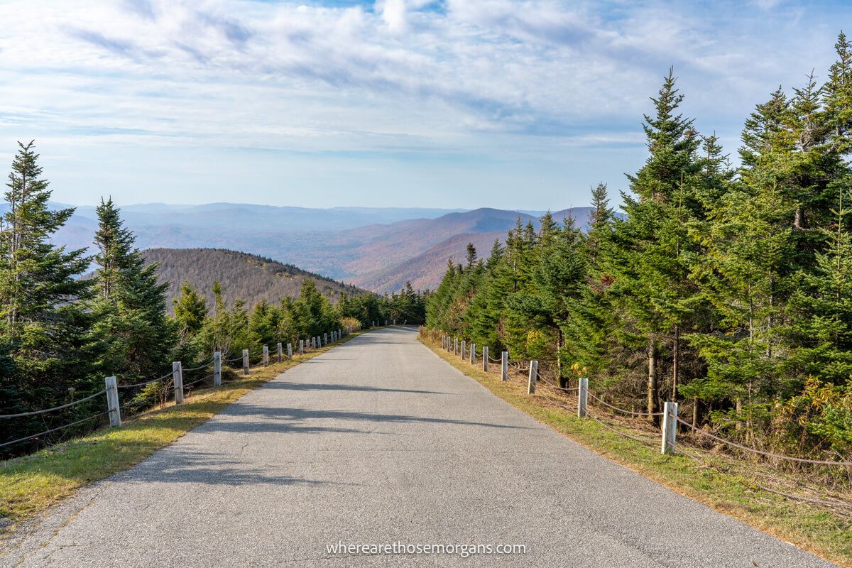 Paved section of road leading down Mt Equinox with the Green Mountains in the distance