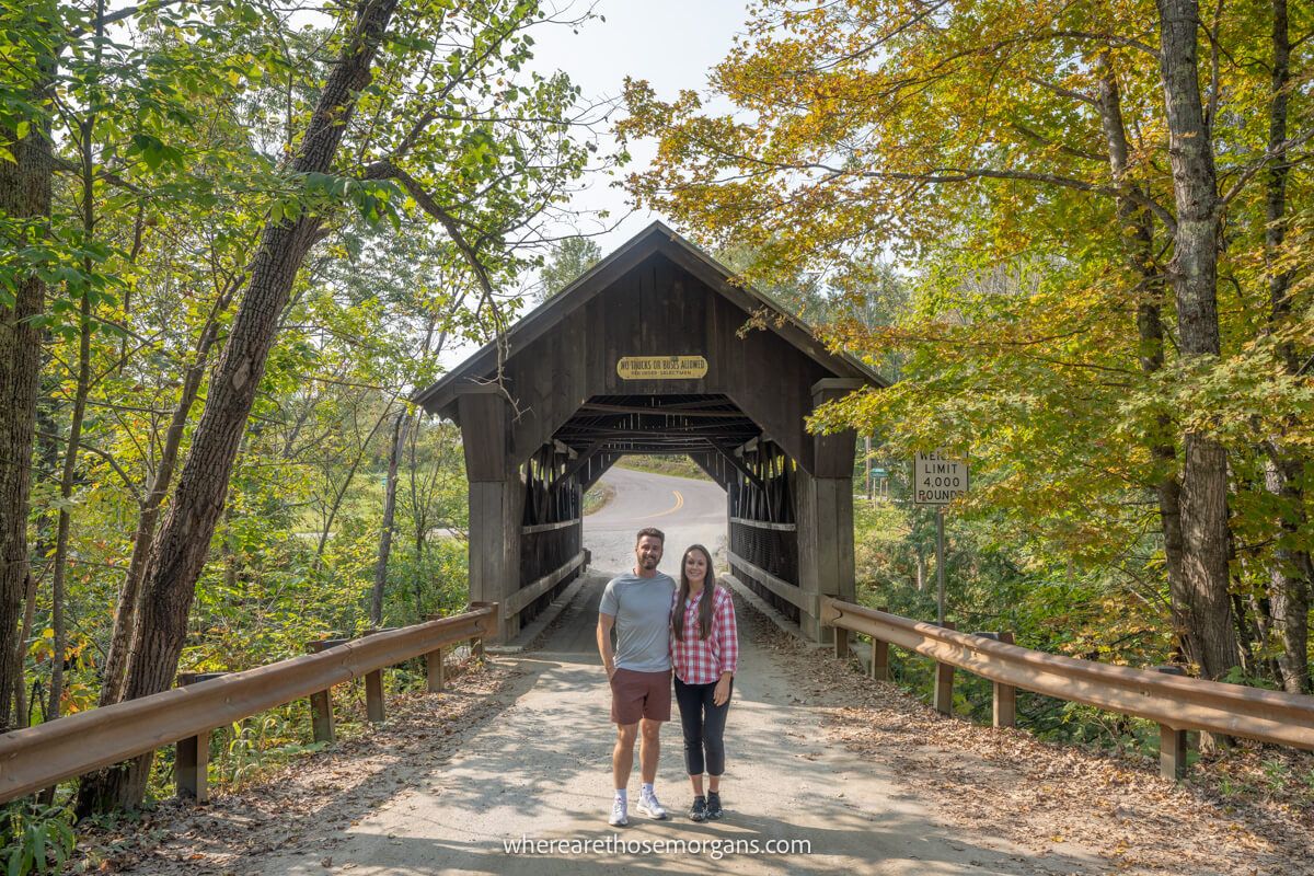 Man and woman posing for a photo in from of Emily's Bridge near Stowe Vermont