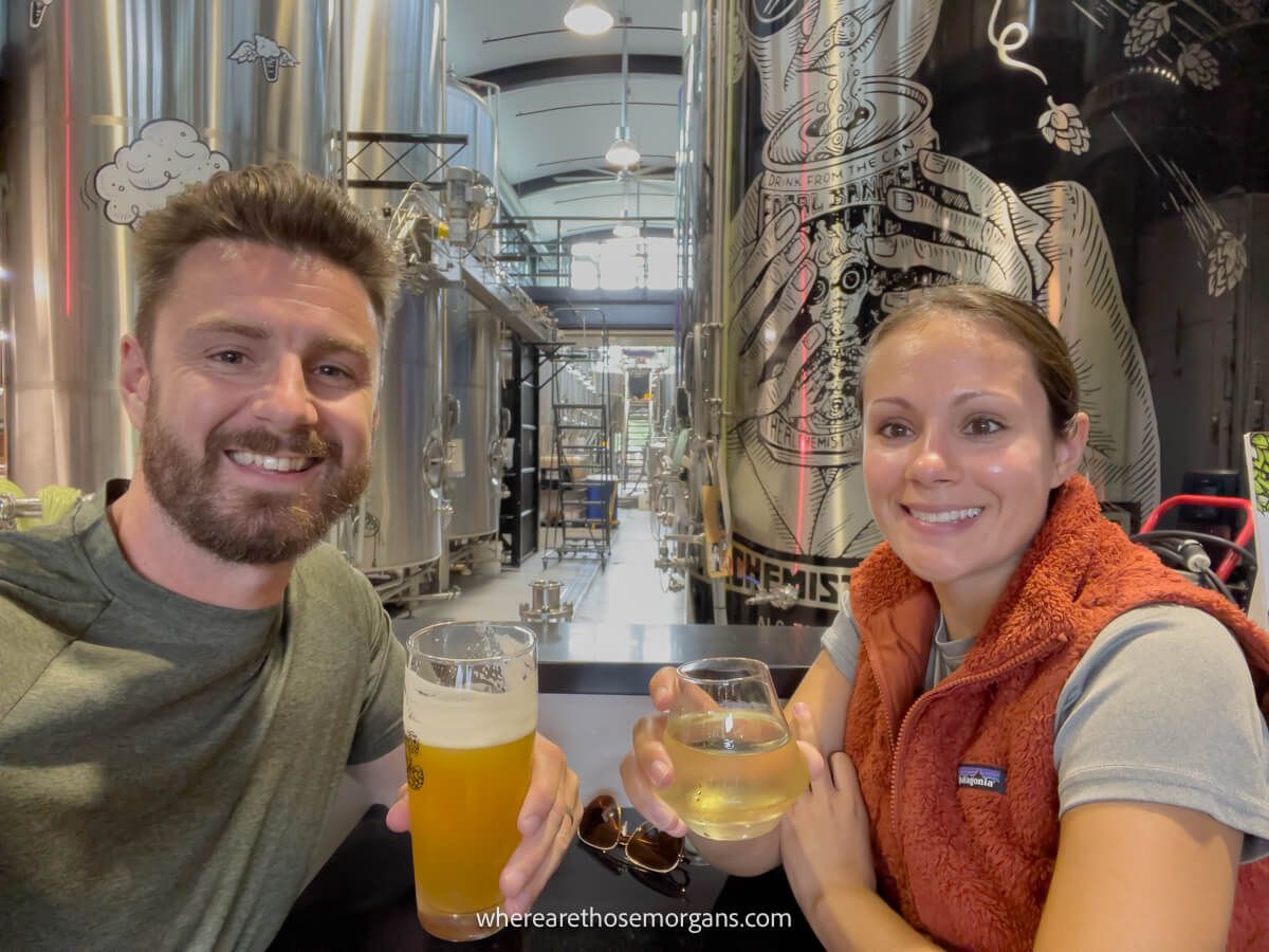 Man and woman taking a photo at the Alchemist in Stowe with two beers