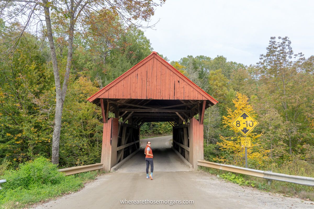 Woman walking through Red Covered Bridge near Stowe, Vermont