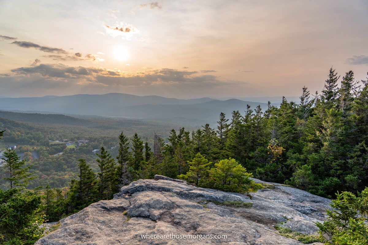 Far reaching views over a wide open rural landscape from a rocky outcrop at sunset