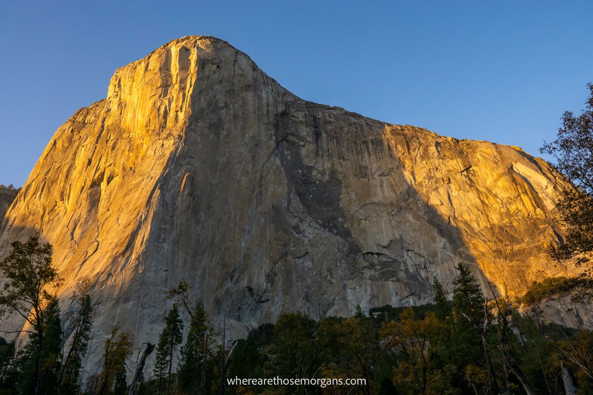 Huge granite rock formation with exposed cliffs and sunlight at dusk on a clear evening