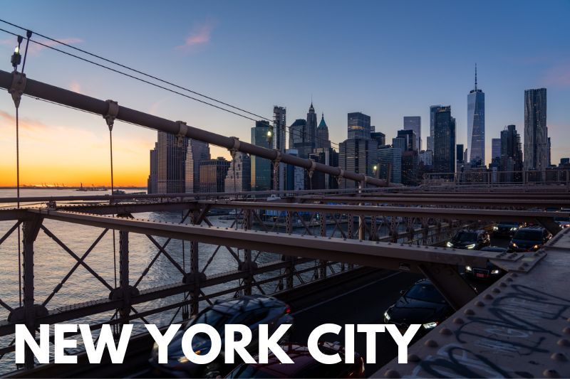 Photo of the NYC skyline at sunset from Brooklyn Bridge with the word New York City overlaid