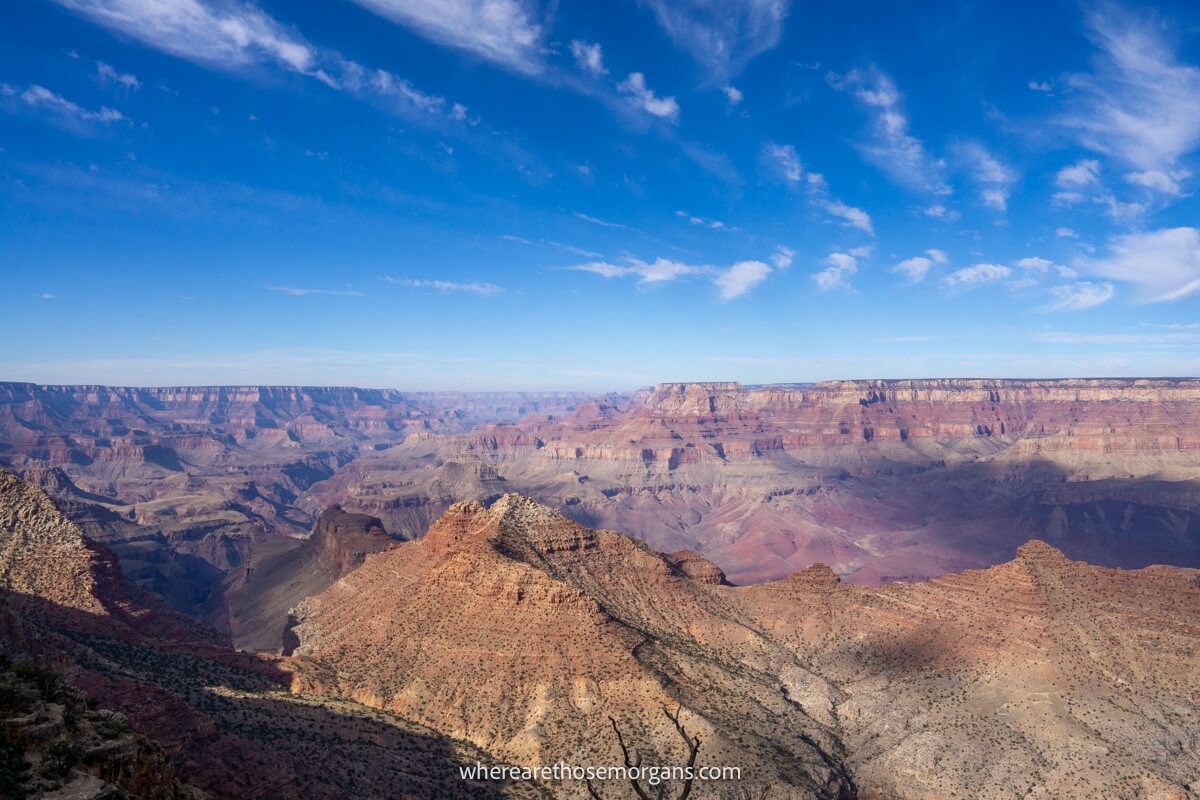 Enormous red and orange sandstone landscape with contrasting highlights and shadows under a brilliant blue sky