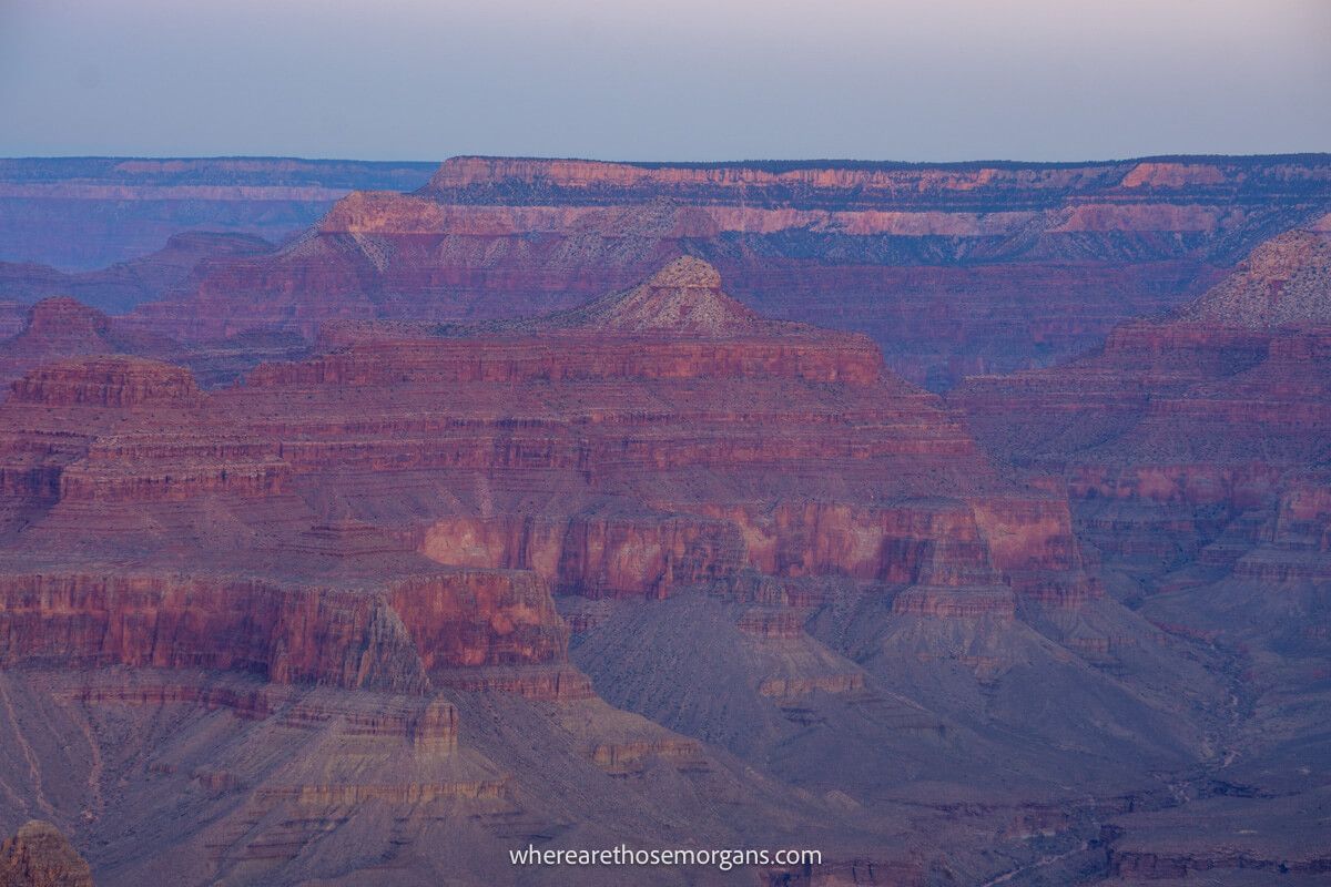 Deep red and purple sandstone rock formations at dawn in Arizona