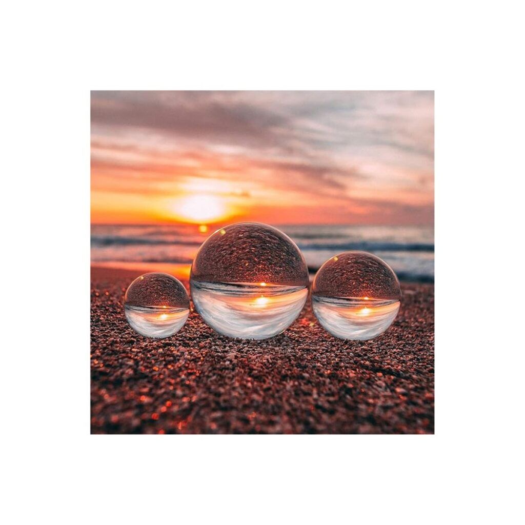 Three crystal balls good to use for photography sitting on a beach