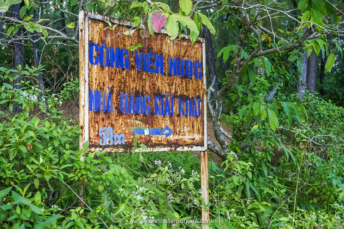 Old rusted sign pointing to Hồ Thuỷ Tiên