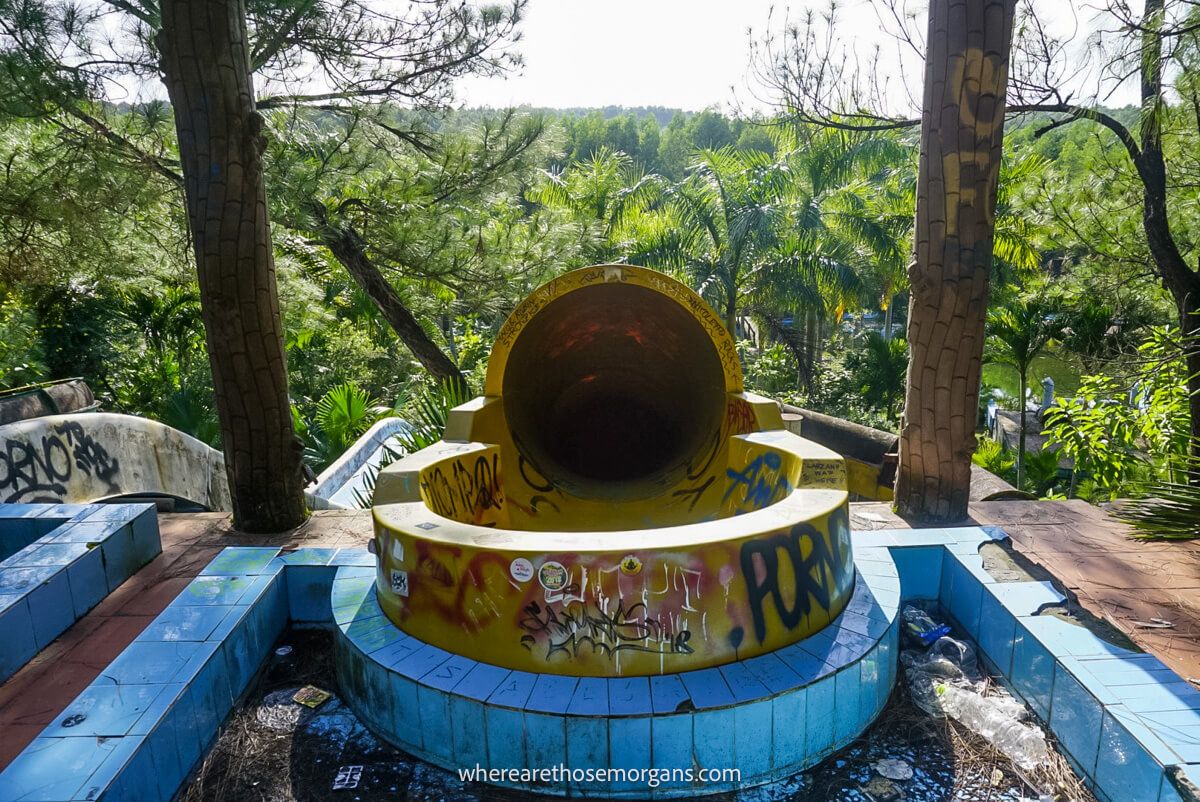 Top of a yellow waterslide with a ton of graffiti