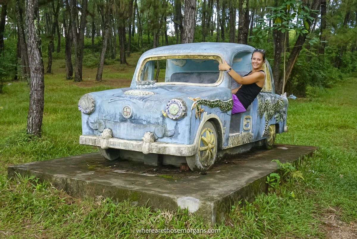 Person sitting in an old car in the middle of the woods in Hue, Vietnam