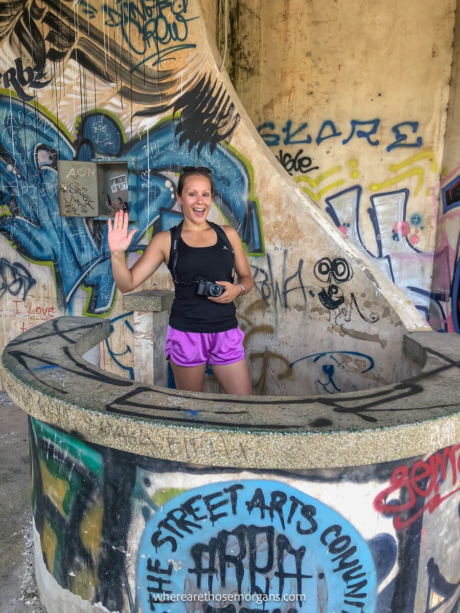 Woman taking a photo behind a table covered in graffiti