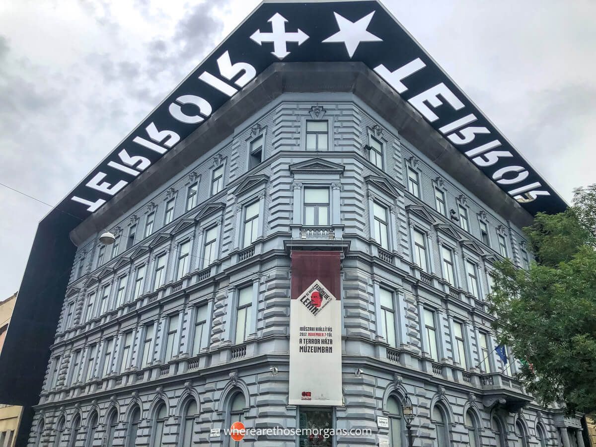 Photo of the corner of a 4 story building with the word TERROR stenciled out of a roof above