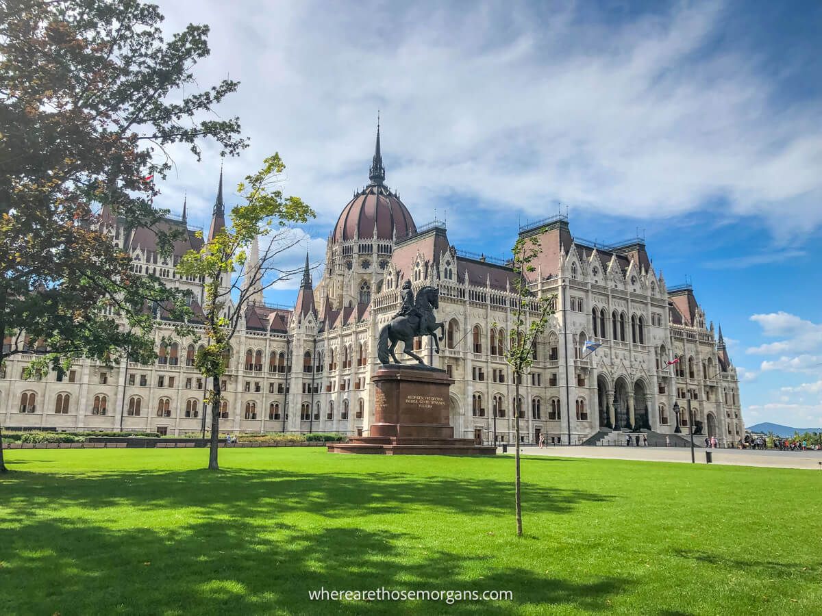 Photo of the impressive Hungarian Parliament Building behind a flat and attractive patch of green grass