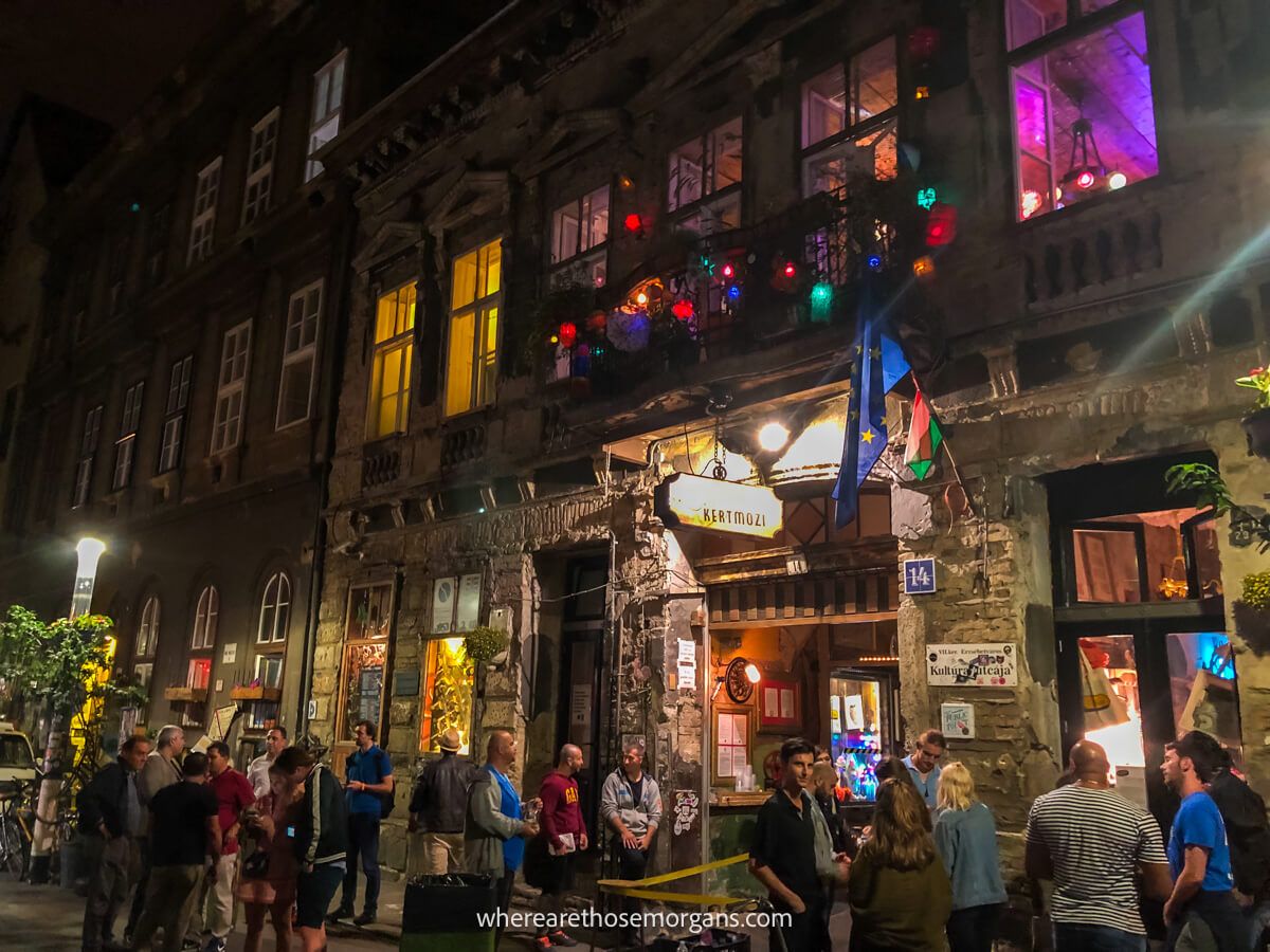 Long line of tourists waiting to go inside a colorful looking bar at night