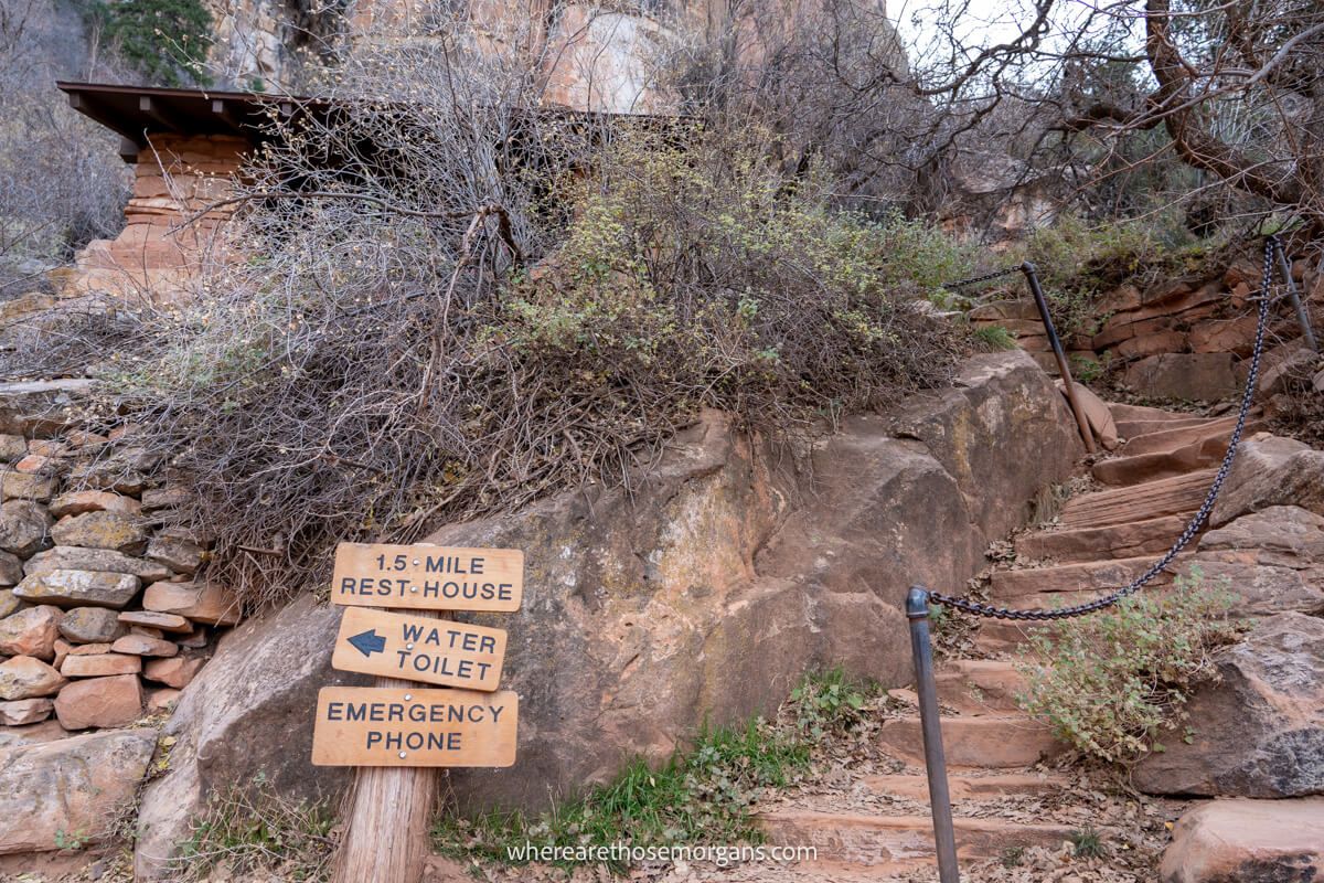 Photo of stone steps next to wooden signs leading to a small brick building
