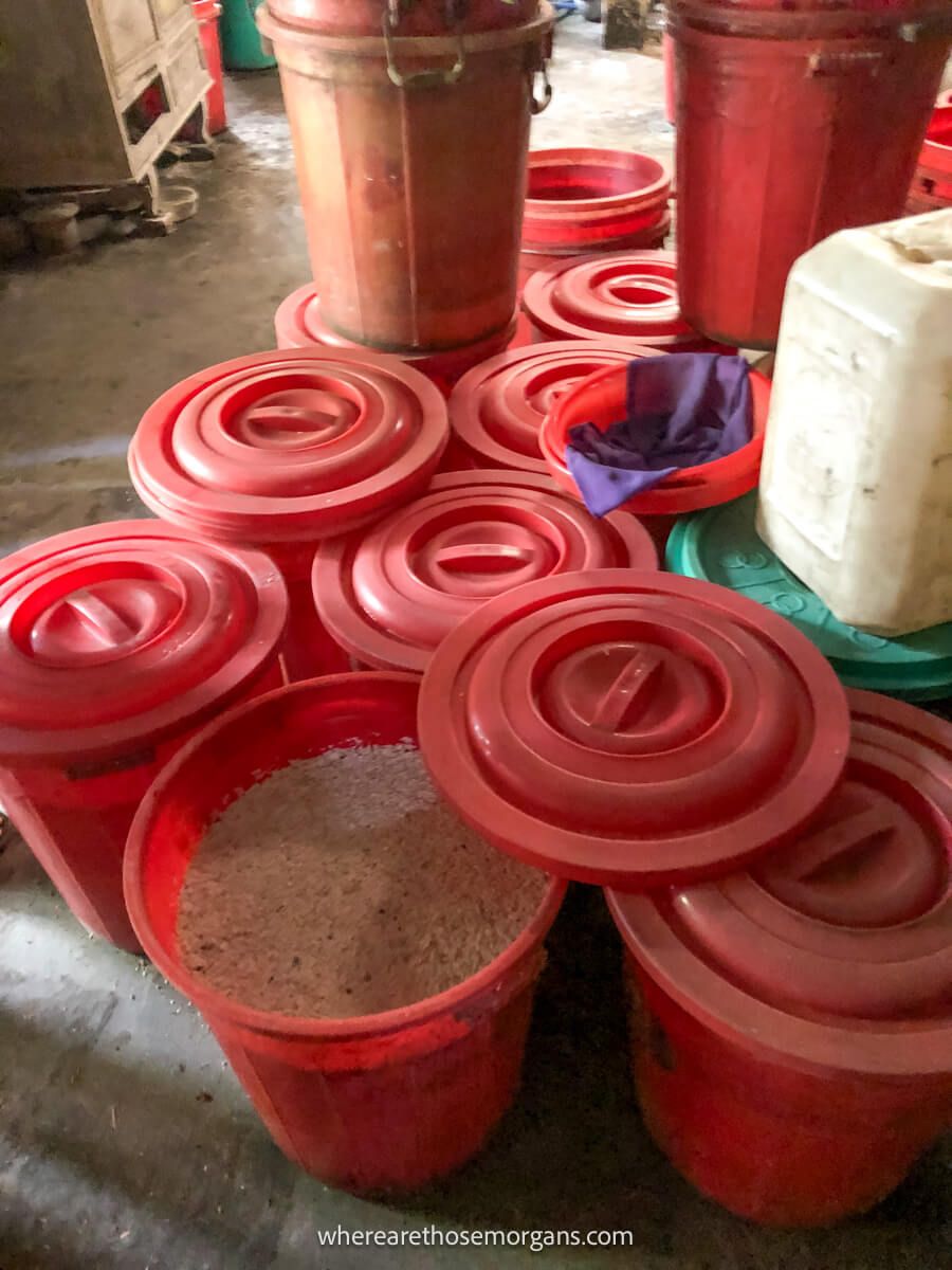 Several large red barrels of rice