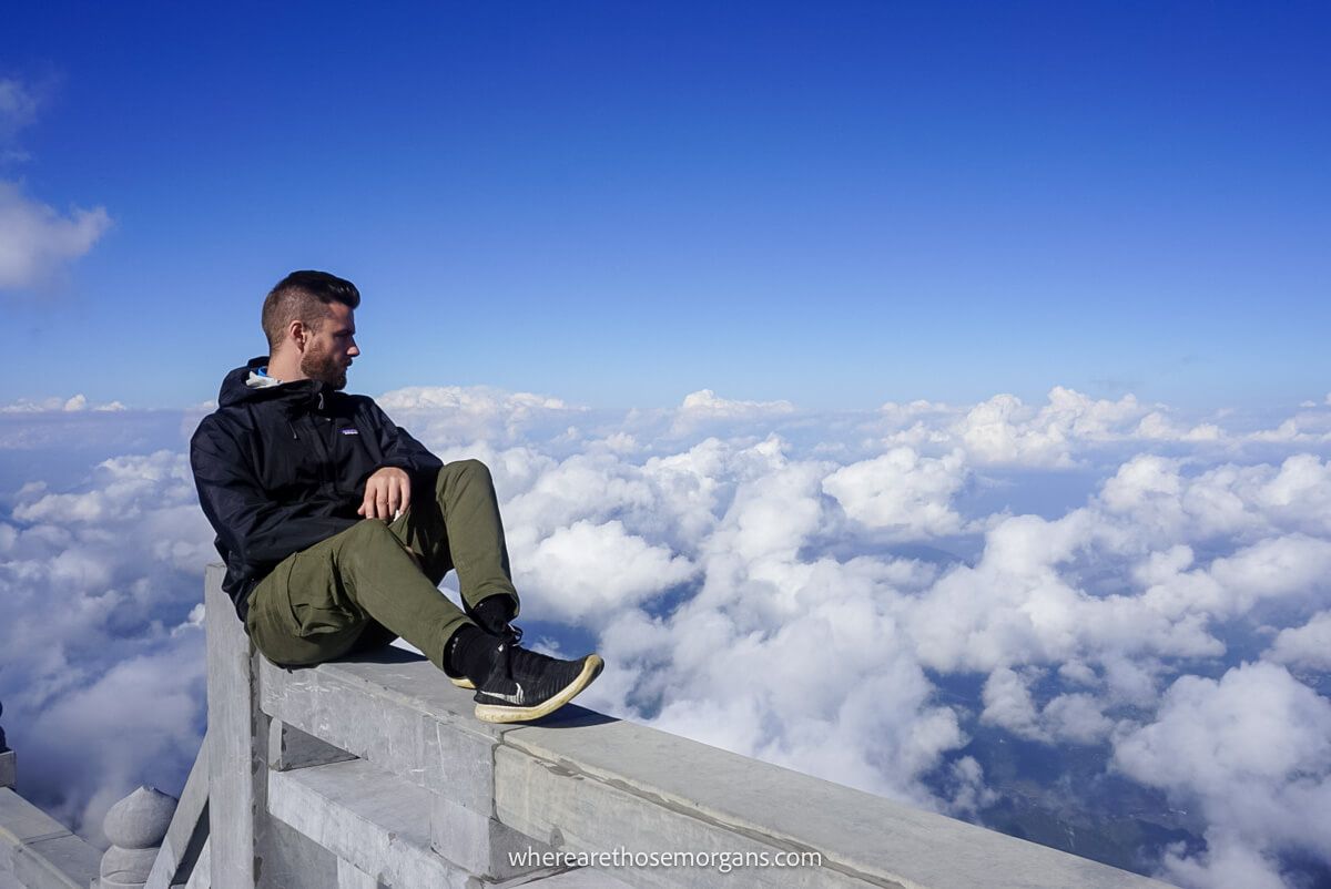 Person sitting on a ledge at the Mount Fansipan summit