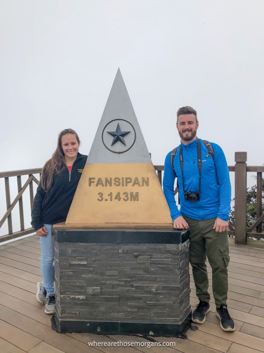 Two people posing for a photo at the top of Mt Fansipan in northern Vietnam