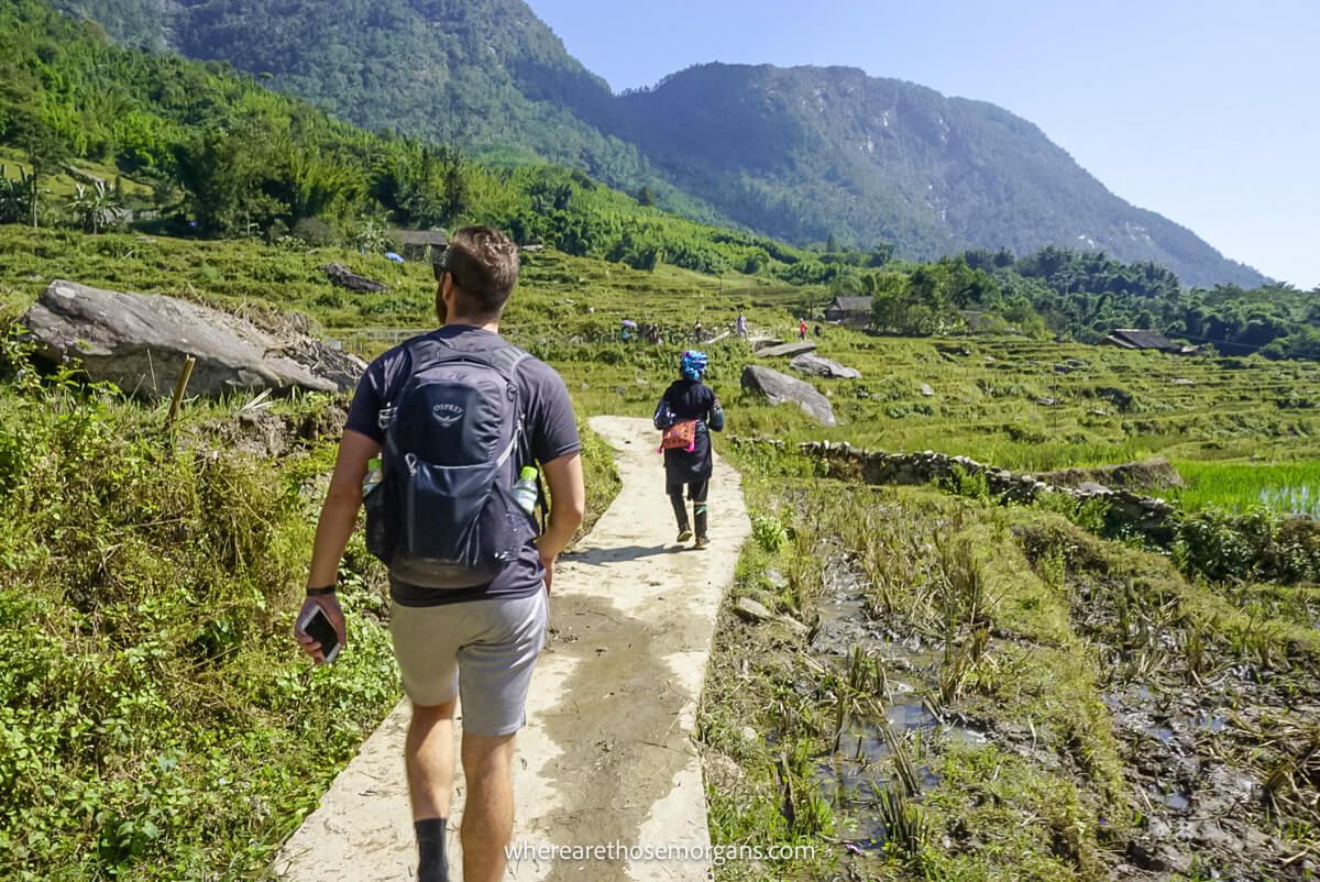 People hiking on a cement path in a village of Vietnam
