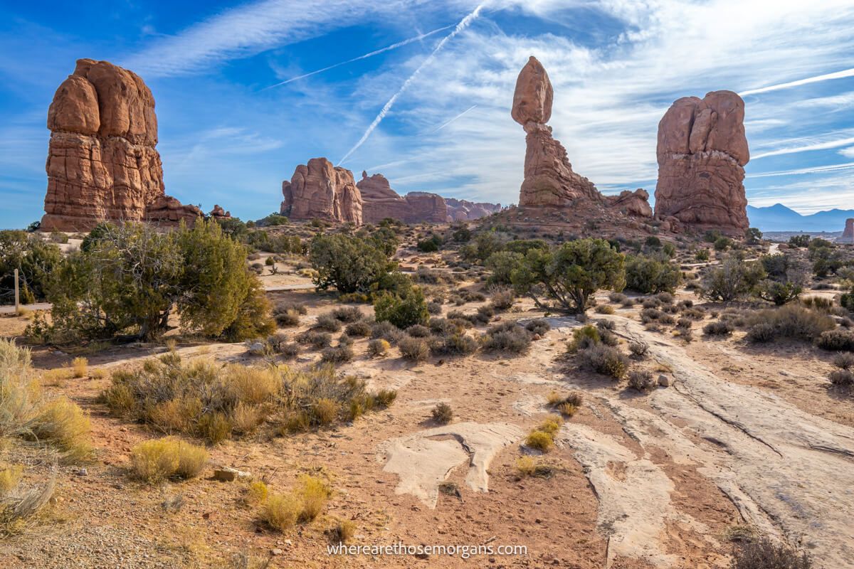 Photo of a desert landscape with tall red rock formations bursting into a blue sky