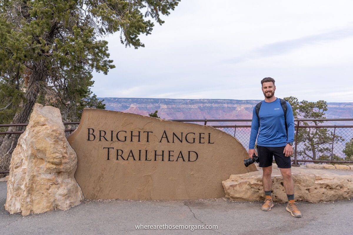Photo of a hiker stood next to the Bright Angel Trailhead sign at Grand Canyon South Rim