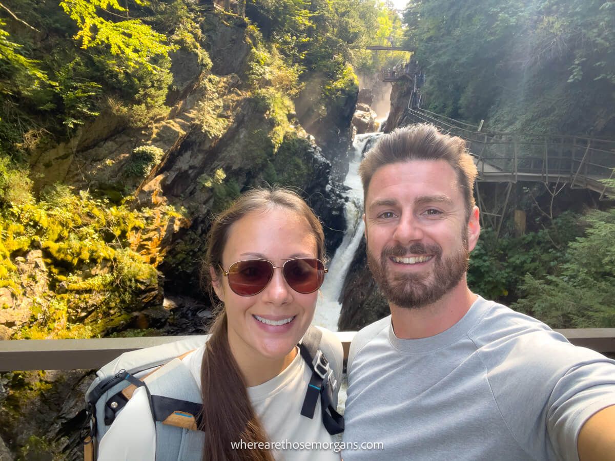 Photo of Mark and Kristen Morgan standing together on a bridge with a view of High Falls Gorge NY in the background